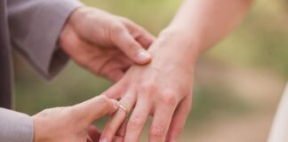 Žiedai iš savo aukso – jaunikis per ceremoniją užmauna auksinį vestuvinį žiedą nuotakai ant rankos.
