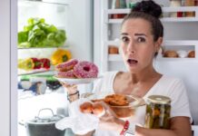 Nuolatinis alkis: kodėl vis norisi valgyti net pavalgius? Nuolatis alkis. Moteris rausiasi po šaldytuvą.