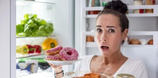 Nuolatinis alkis: kodėl vis norisi valgyti net pavalgius? Nuolatis alkis. Moteris rausiasi po šaldytuvą.